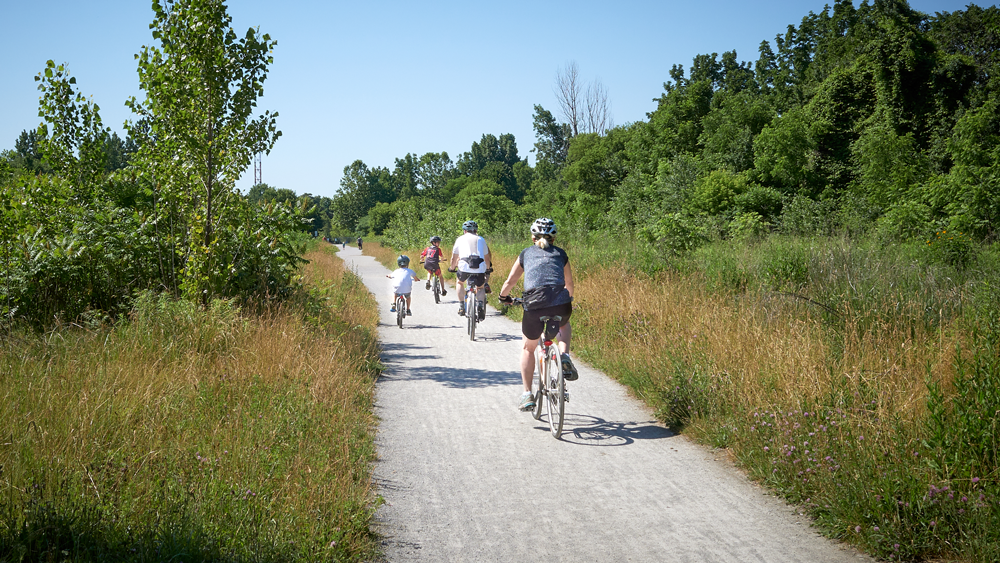 Family biking on path in nature (St. Catharines, Ontario)
