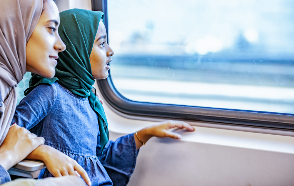 Une mère et sa fille assises dans un train et regardant par la fenêtre